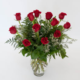 Red roses arranged in a clear glass vase