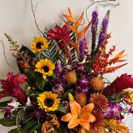 Colorful tropical bouquet with sunflowers, lilies, orchids, and orange bird-of-paradise