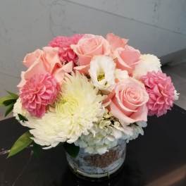 Pink roses and white chrysanthemums arranged in a small vase