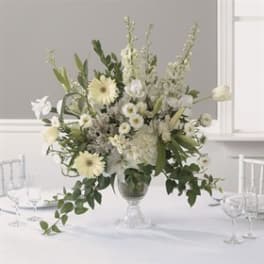 White floral centerpiece in a glass vase on a table