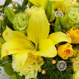 Yellow lilies and roses with green blooms and gold bead accents