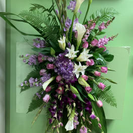 Tall floral spray with white calla lilies, pink roses, and purple blooms