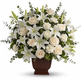 White lilies and cream roses arranged in a brown urn vase