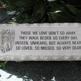 Memorial plaque with an angel and sympathy verse surrounded by plants