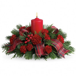 Red candle centerpiece with pine, red flowers, and plaid ribbon