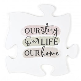 White puzzle piece sign with the words "Our story Our life Our home"