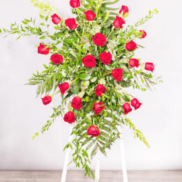 Tall arrangement of red roses on a white stand