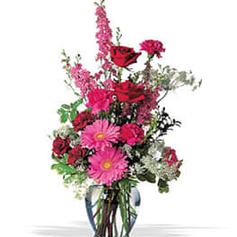 Pink and red mixed flower arrangement in a glass vase