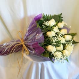Bouquet of white roses wrapped in purple paper