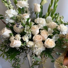 White and blush floral arrangement in a clear glass vase