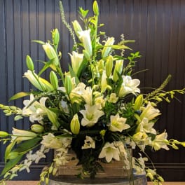 Large white lily arrangement in a clear vase