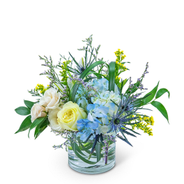 Blue and cream flowers in a clear glass vase