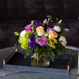Mixed bouquet of roses and lisianthus in a glass vase