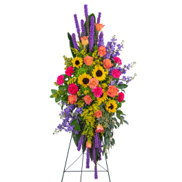 Tall standing floral spray with sunflowers, roses, and purple spikes