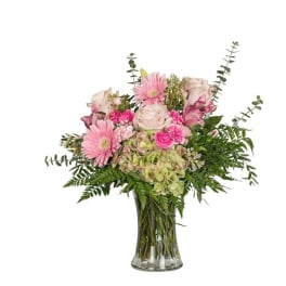 Pink and white mixed flowers in a clear glass vase