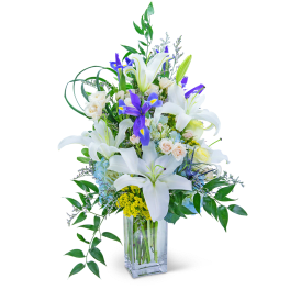 White lilies and purple irises in a clear glass vase