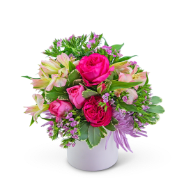 Pink roses and pale lilies arranged in a white vase