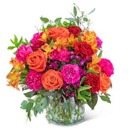 Mixed bouquet of orange and pink flowers in a glass vase