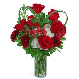 Red roses and carnations in a clear glass vase