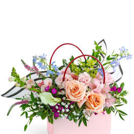 Pink gift box with a mixed bouquet of roses and pastel flowers