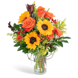 Bouquet of orange roses and yellow sunflowers in a clear glass vase