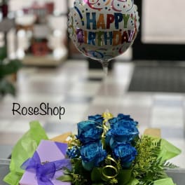 Blue roses with a happy birthday balloon and gift box