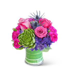Pink roses and purple flowers in a green glass vase
