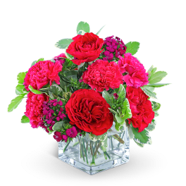 Red roses and pink carnations in a clear square vase