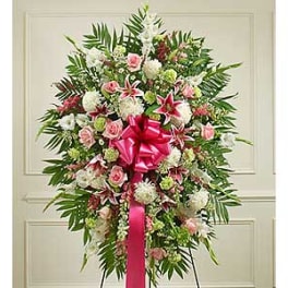 Large standing floral spray with pink and white flowers and a pink ribbon