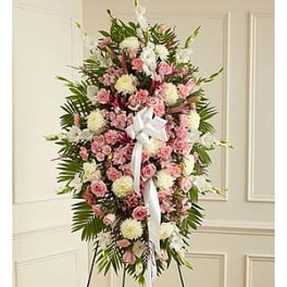 Standing spray of pink and white flowers with a white ribbon