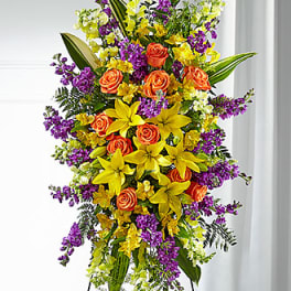 Tall floral spray with orange roses, yellow lilies, and purple flowers