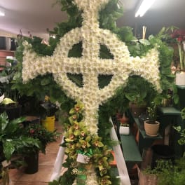 Large white floral standing tribute with a cross design and orchids