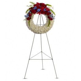 Standing floral wreath on an easel with red, white, and blue flowers