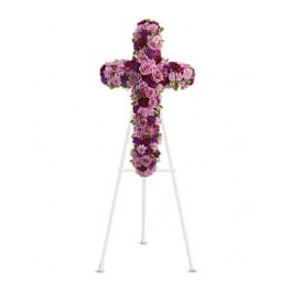Purple and pink floral cross on a white stand