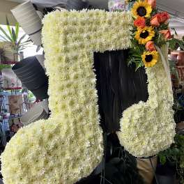 Large floral number-shaped display made of white chrysanthemums with sunflowers and roses