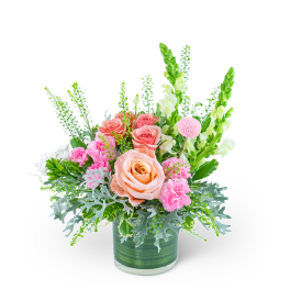 Pink and peach roses with carnations in a green glass vase