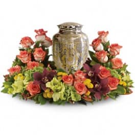 Floral arrangement with pink roses around a decorative urn