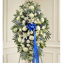 Large white and blue funeral spray with a blue ribbon
