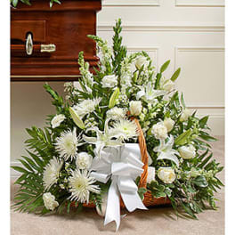 White funeral basket arrangement with lilies and roses