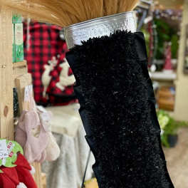 Black memorial spray with tan dried grass in a silver vase