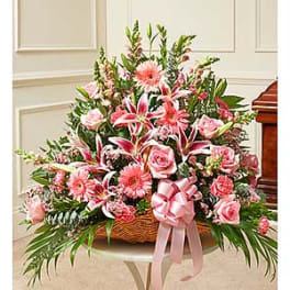 Pink floral basket arrangement with roses, lilies, and gerbera daisies
