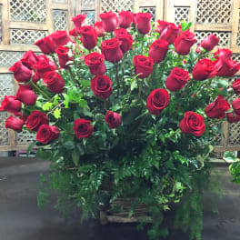 Large bouquet of red roses with greenery in a basket