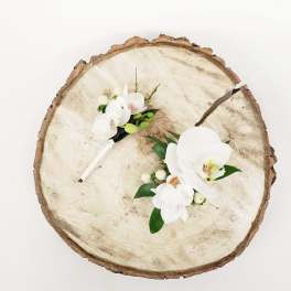 White orchid corsages on a wood slice background