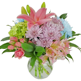 Pink lilies and mixed pastel flowers in a clear glass vase