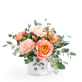 Peach and pink roses with carnations in a white vase