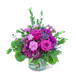 Pink and purple flower arrangement in a clear glass vase