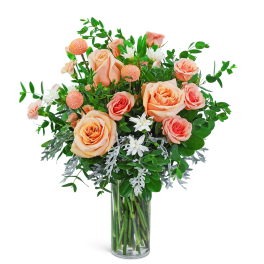Peach and coral roses in a clear glass vase with white accent flowers