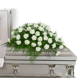 White floral casket spray with greenery on a silver casket
