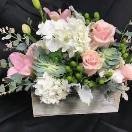 Pink roses and white hydrangeas in a wooden box arrangement
