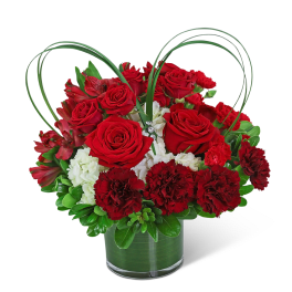 Red roses and carnations in a glass vase with heart-shaped loops